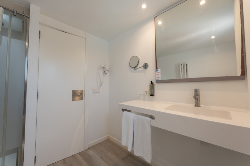 Baño Estudio Superior 2 Baño con espejo, lavabo y amenities del estudio superior