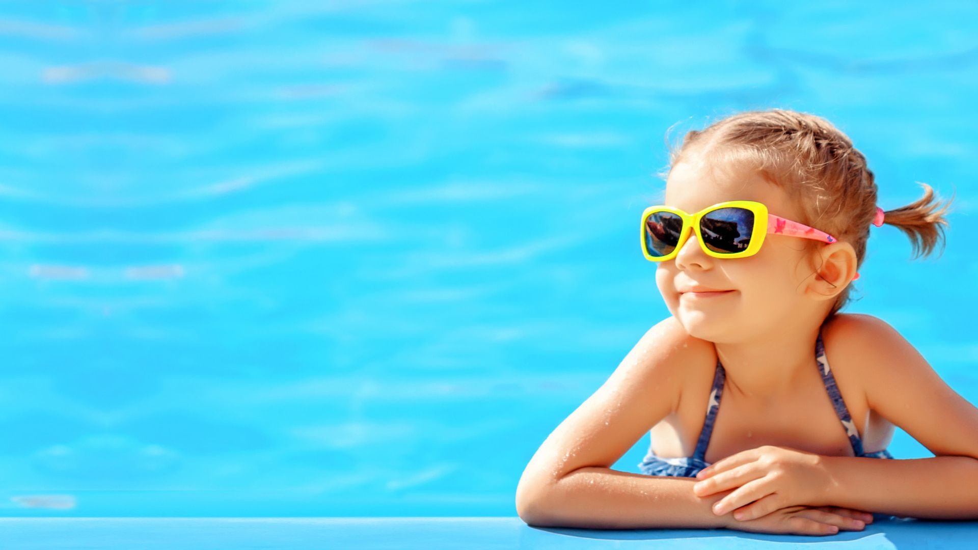 Niña disfrutando de la piscina del hotel