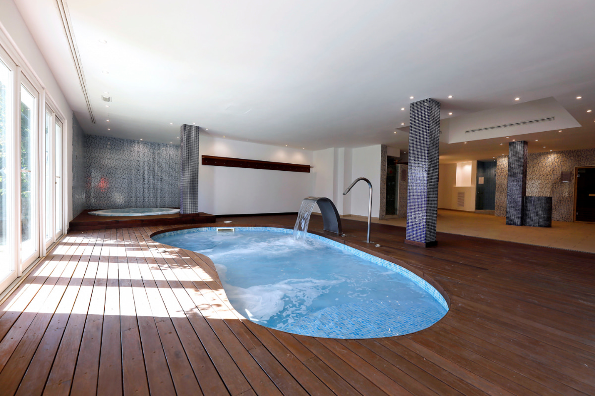 Heated indoor swimming pool with jacuzzi at the back