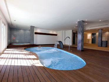 Heated indoor swimming pool with jacuzzi at the back