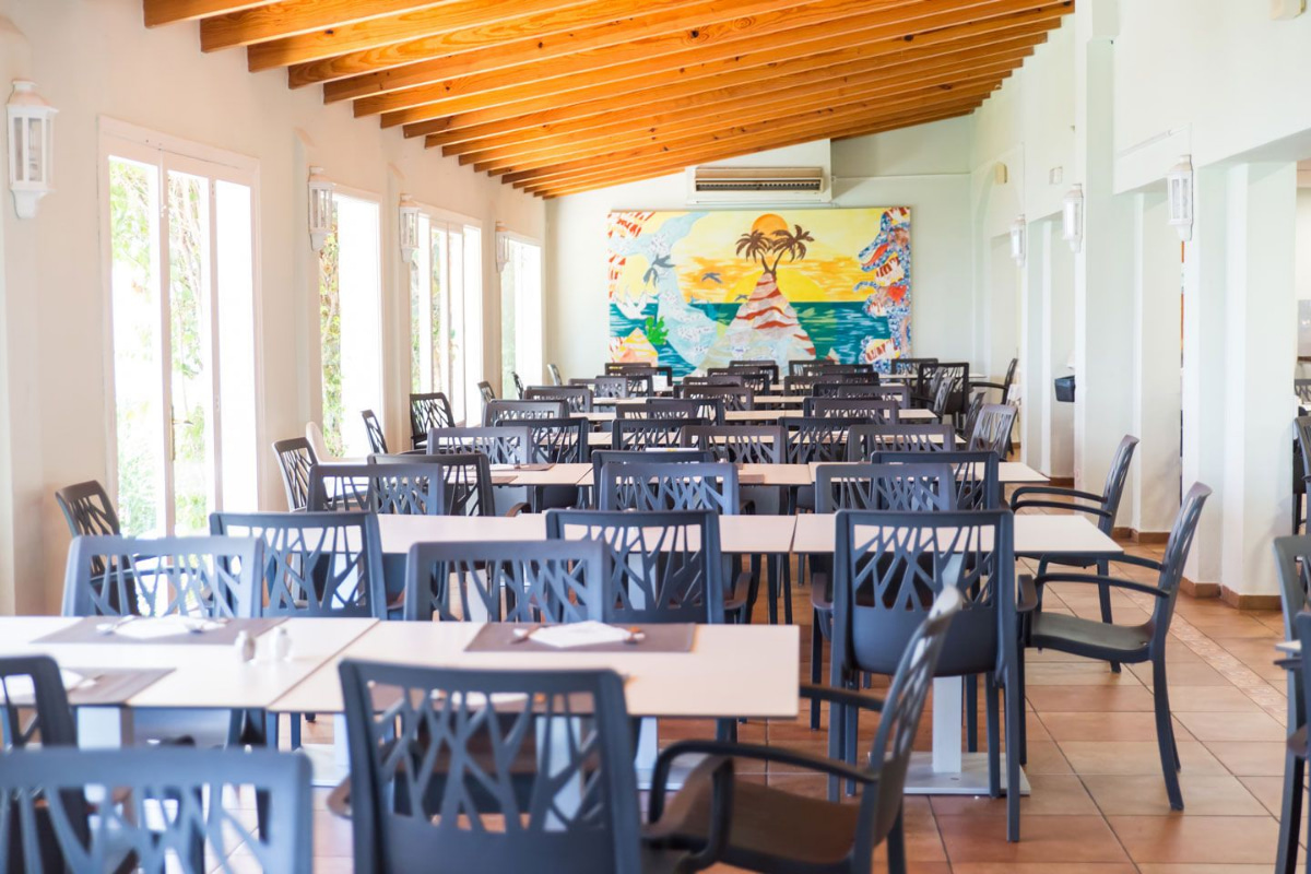 Tables and chairs in the dining room of Hotel Club es Talaial