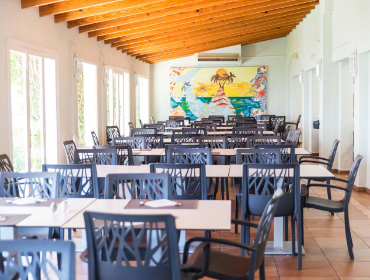 Tables and chairs in the dining room of Hotel Club es Talaial